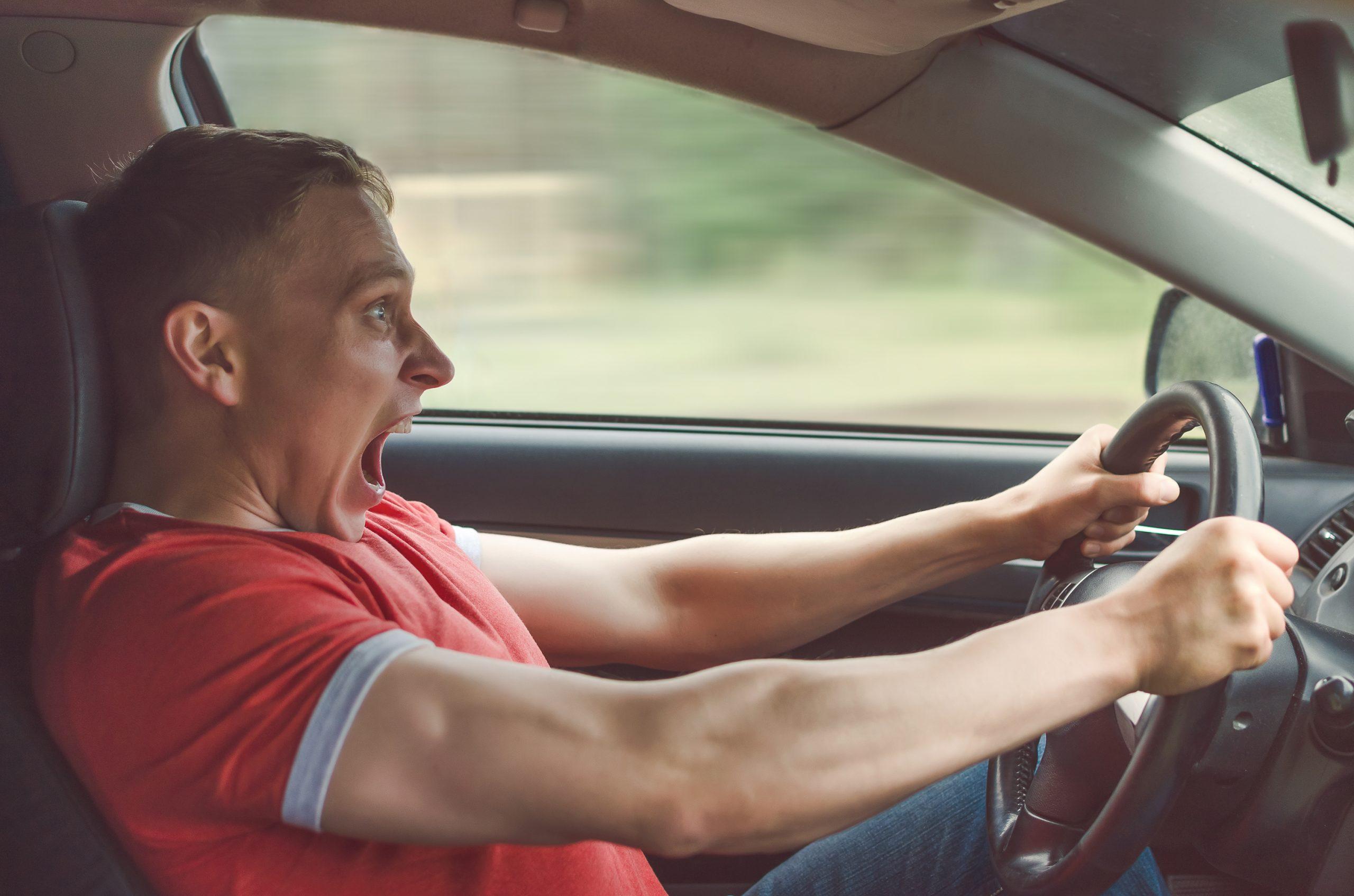 Image of a man driving a car stomping on the brakes