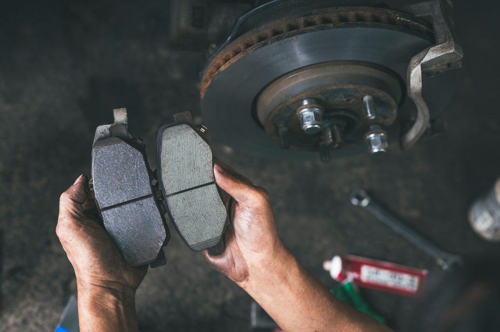 image of mechanics holding brake pads in each hand