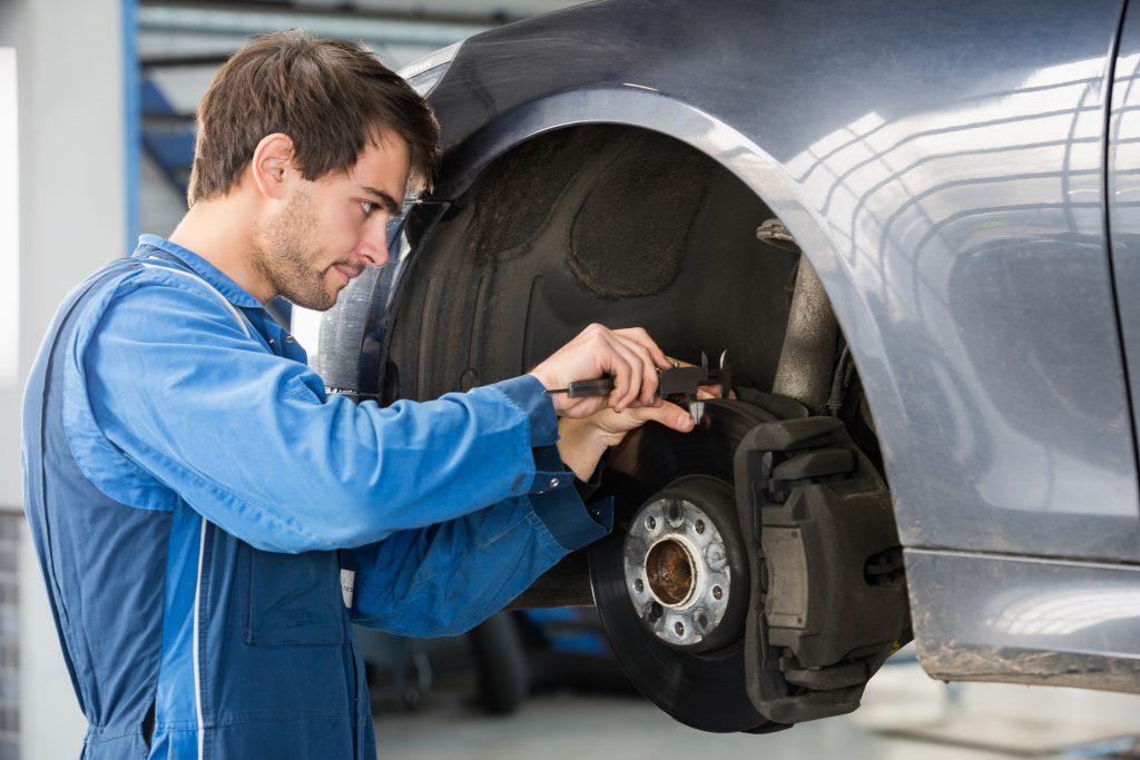 Image of mechanic working on front brakes of a vehicle