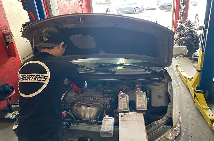 Silver car with open hood, mechanic prepare oil change