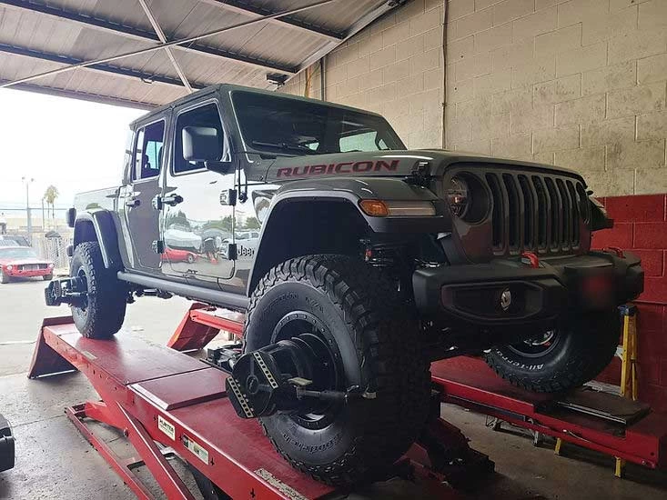 Jeep Gladiator on alignment rack with wheel sensors, ready for alignment