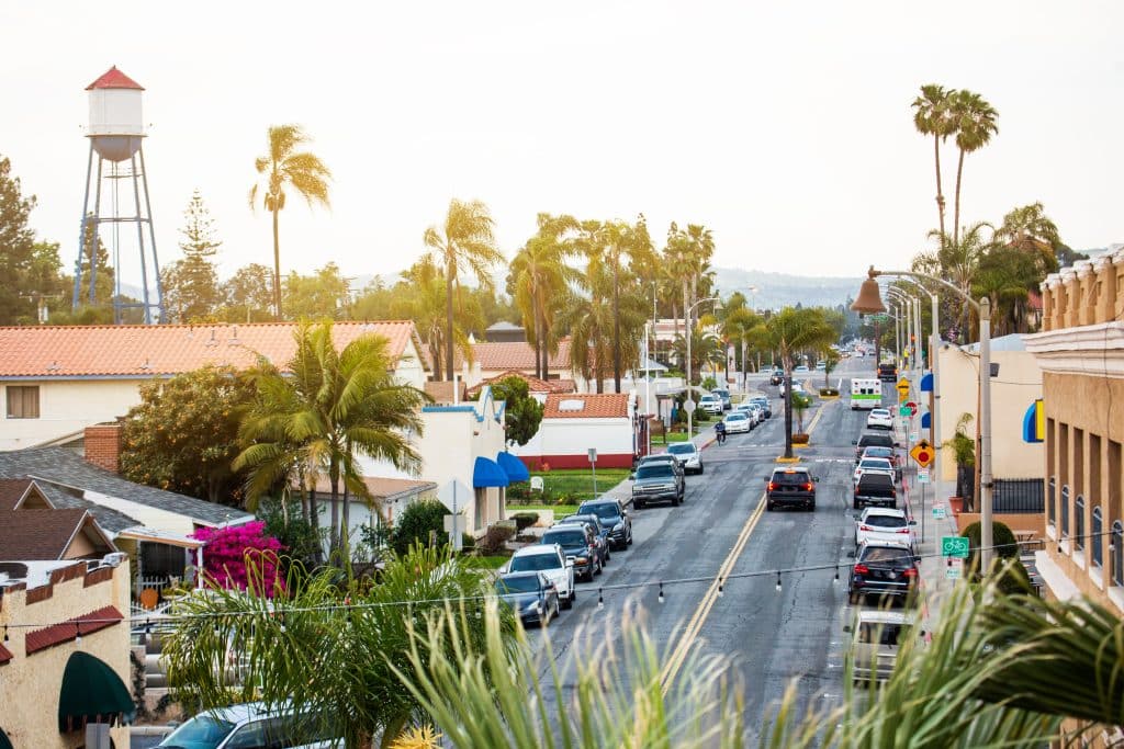 Tree-lined street view in Placentia, CA with historic water tower, palm trees, and residential homes in a suburban neighborhood