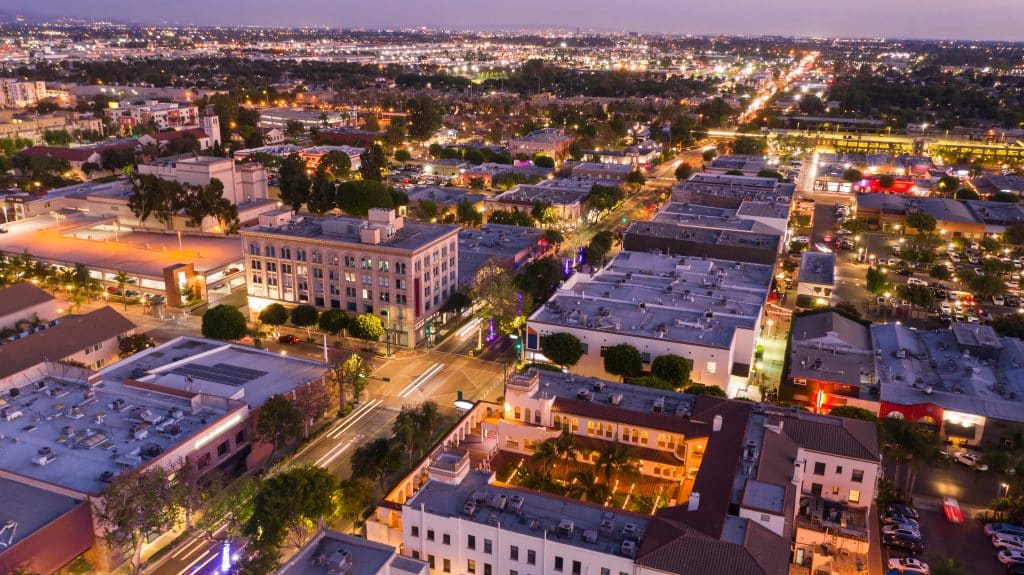 Aerial view of downtown Fullerton, CA at dusk with city lights, buildings, and busy streets in northern Orange County